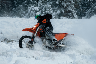 Person riding a snow bike through a snowy trail, representing recreational insurance coverage