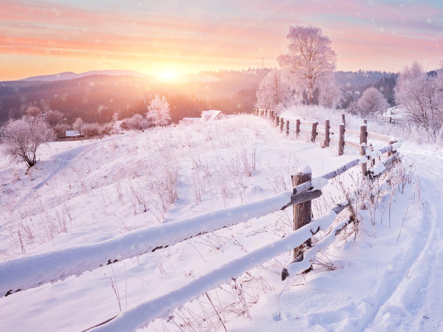 Snow-covered rural Nebraska landscape with a wooden fence at sunrise